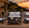 Black aluminum outdoor patio furniture set with gray cushions on luxury terrace at sunset, featuring loveseat, armchairs, and coffee table by infinity pool
